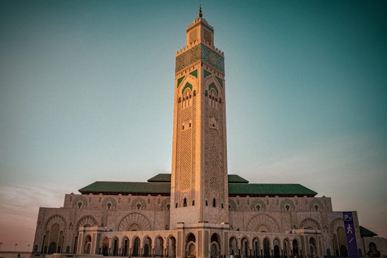 The majestic Hassan II Mosque in Casablanca, Morocco, beautifully lit at sunset.