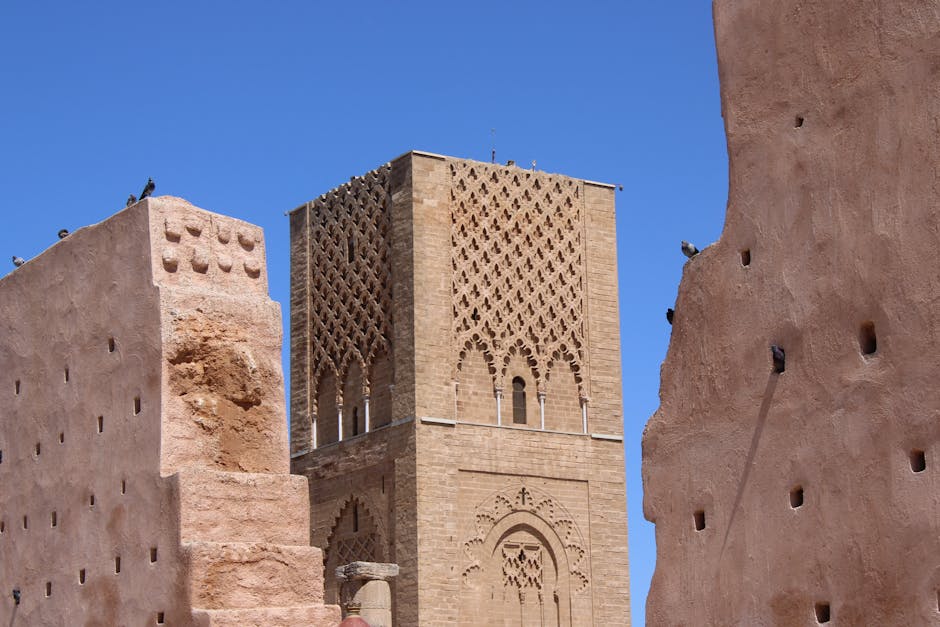 Historic Hassan Tower and ancient walls in Rabat, Morocco under a clear blue sky.